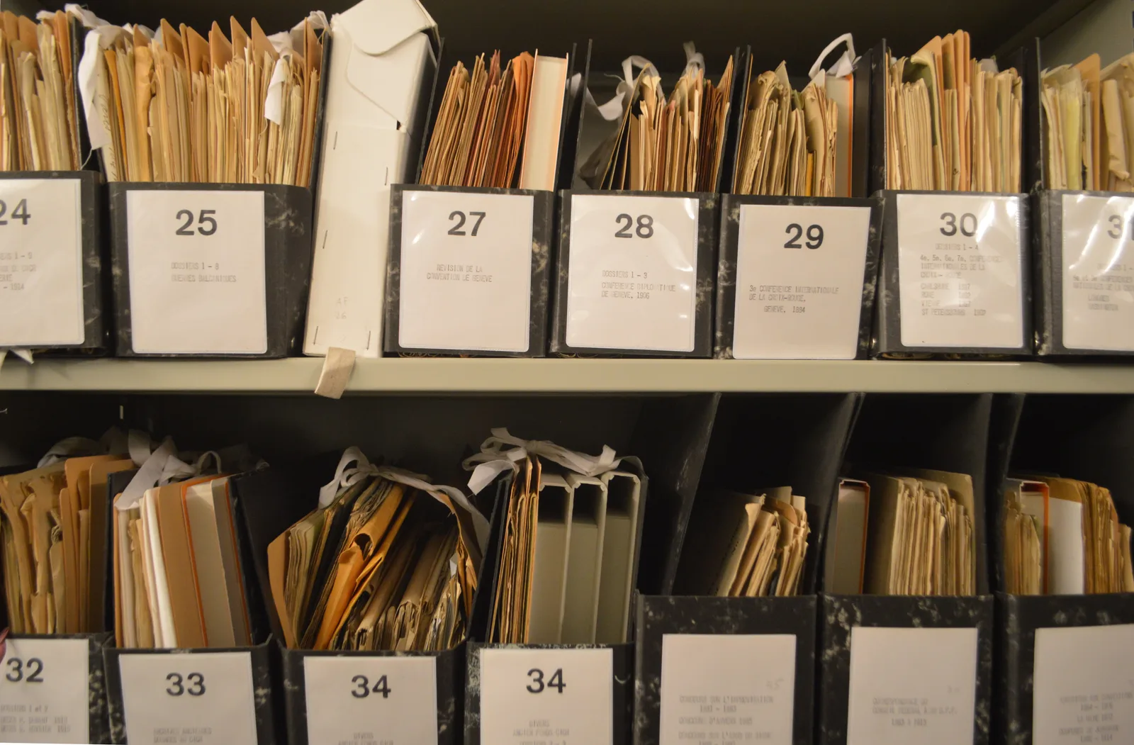 Rows of archival record boxes stored on metal shelves