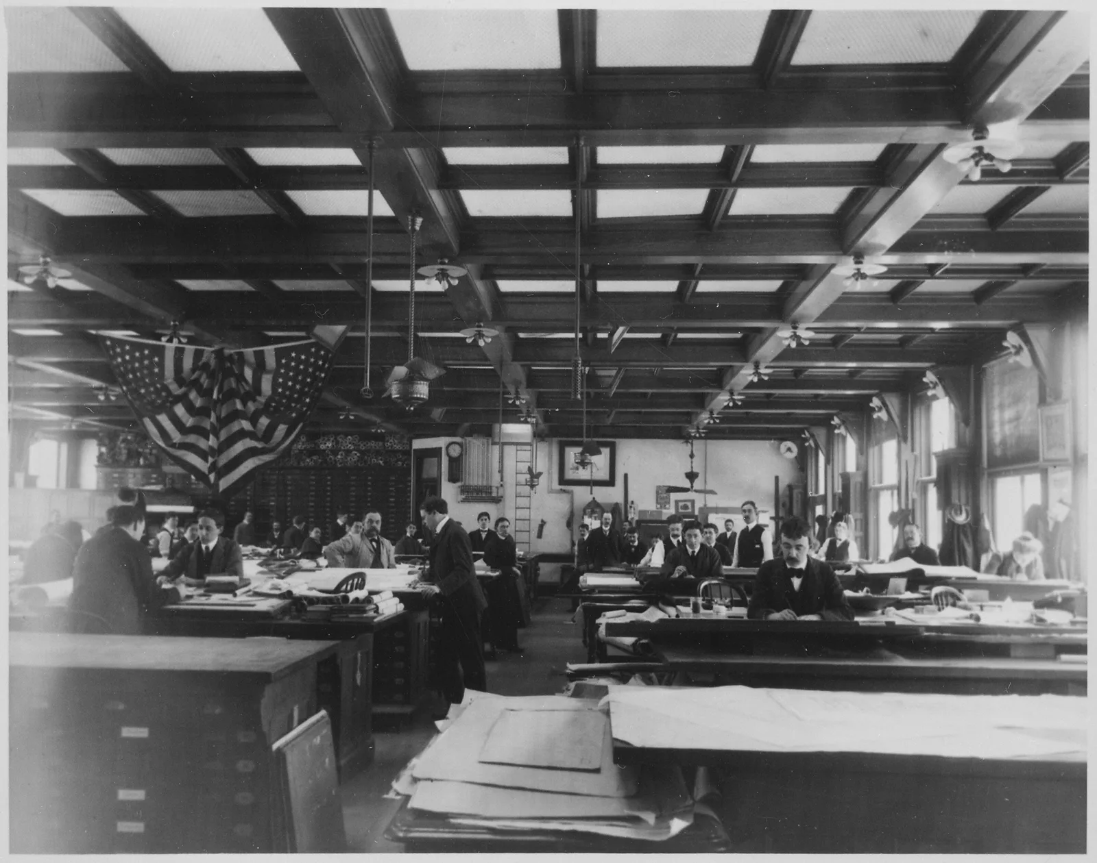 Architects working at drafting tables covered with plans