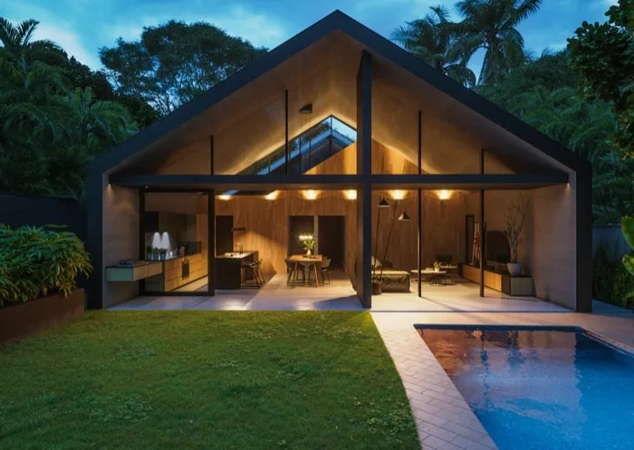 3D render of a glass-walled home at dusk with a pool and palm trees