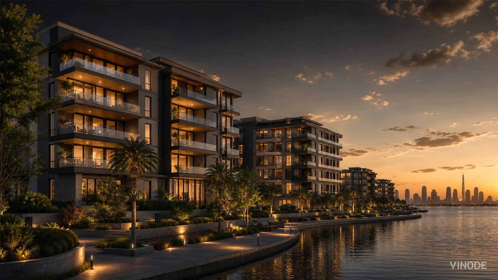 Waterfront apartment towers lit at dusk beside a promenade and city skyline