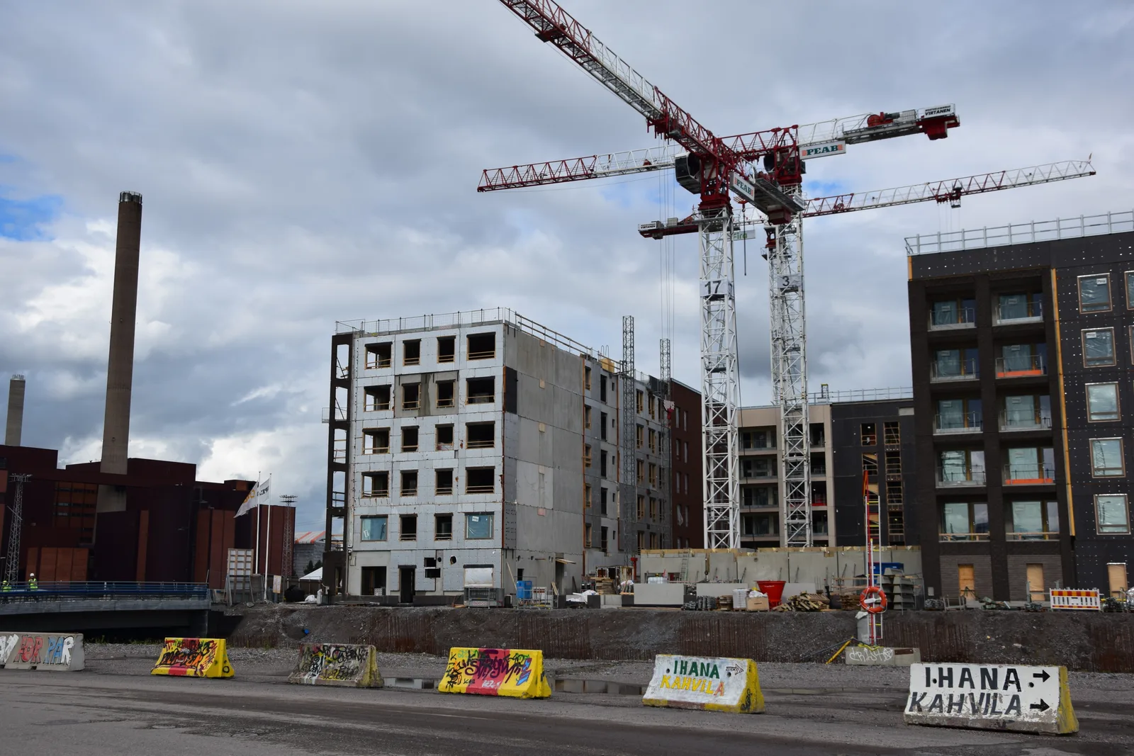 Apartment buildings at different stages of construction beneath tower cranes