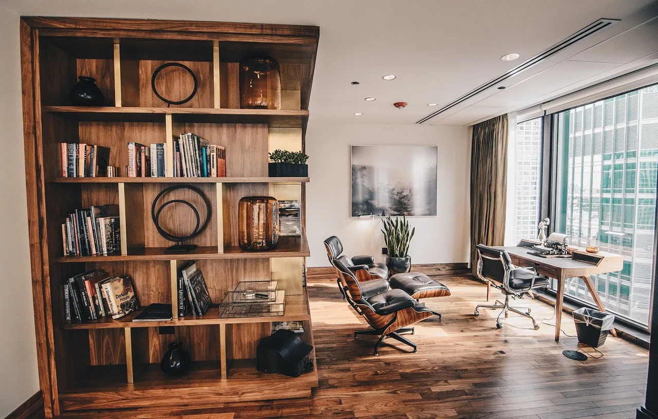 Modern loft office with wooden shelving, lounge chair, and city-view windows